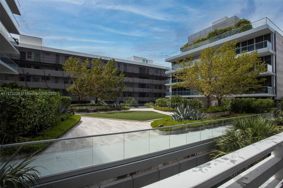 View of a courtyard surrounded by modern multi-story buildings with greenery and pathways.