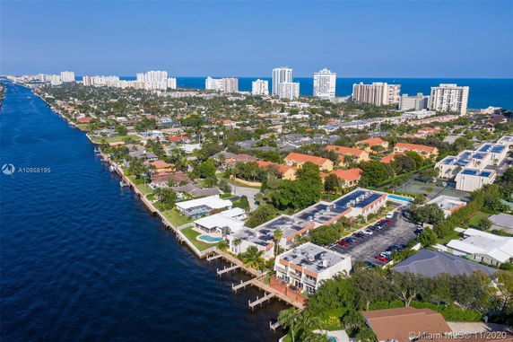 Panoramic view of a coastal residential and urban area with waterways and tall buildings.