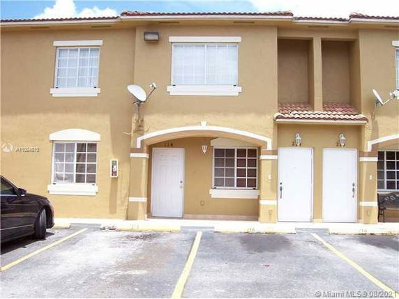Front view of a two-story building with parking spaces in front.