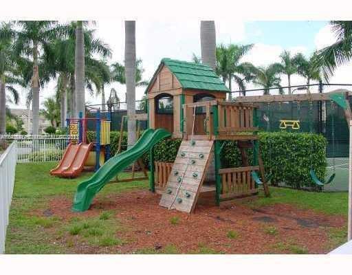 Outdoor playground with a climbing structure, slides, and swings.
