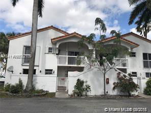 Front view of a two-story house with balconies and white exterior walls.