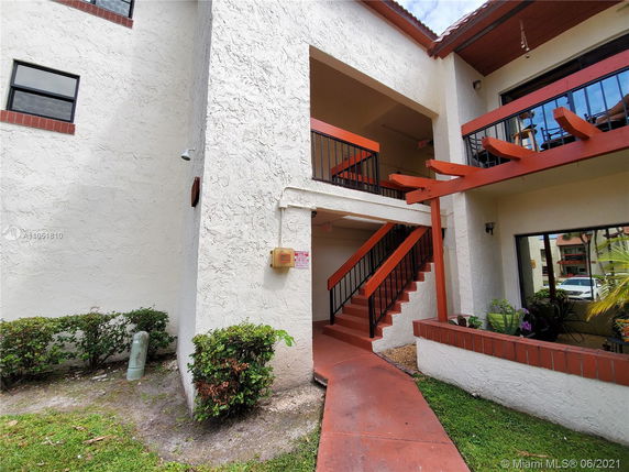 Front view of a two-story building with external staircase.