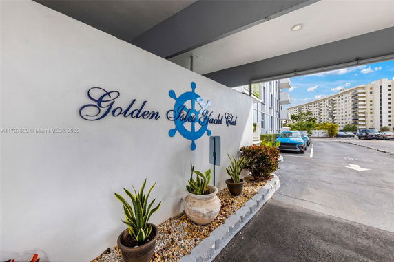 Entrance of a building with parking lot and signage reading 'Golden Isles Yacht Club.'