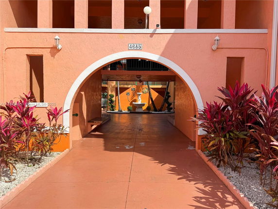 Front view of a building with an arched entrance and peach-colored walls.