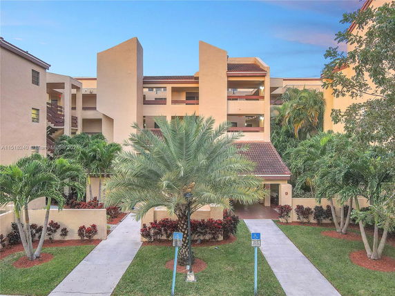 Front view of a multi-story residential building with a landscaped entrance.