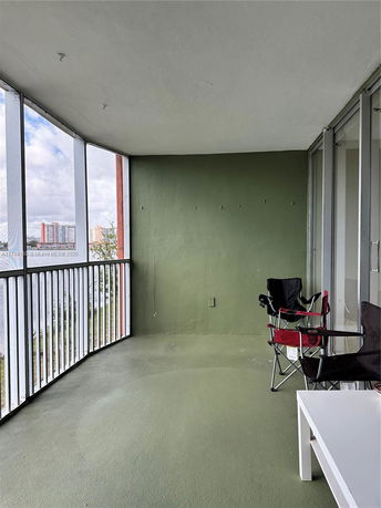 Balcony view with railing overlooking surrounding buildings.