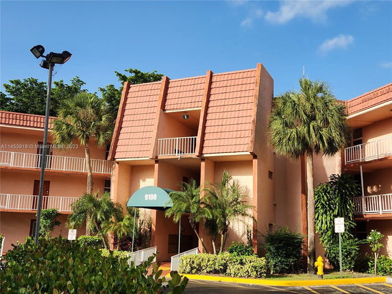 Front view of a multi-story building with a terracotta facade and white railings.