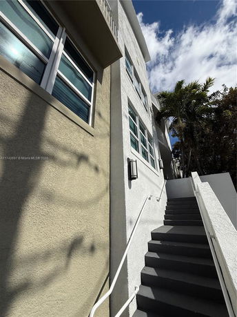 Side view of a multi-story building with stairs leading up.