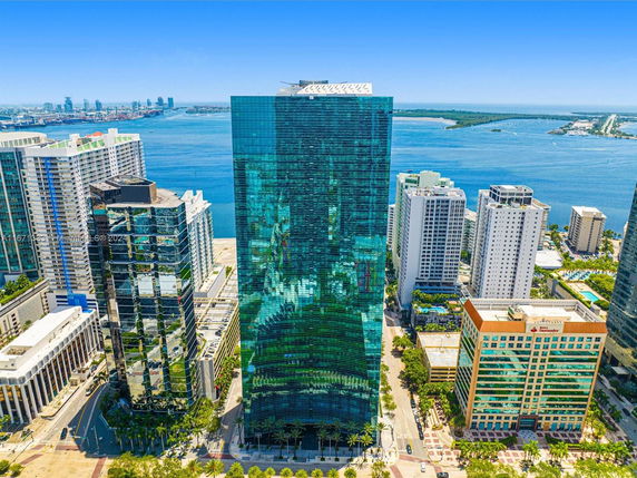 Aerial view of a tall modern glass building in a cityscape.