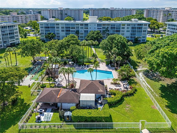 Aerial view of an outdoor swimming pool surrounded by a residential apartment complex.