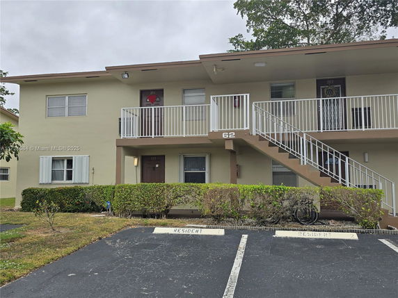 Front view of a two-story apartment building with an external staircase.