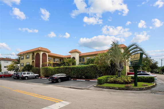 Front view of a two-story condominium building with a landscaped entrance.