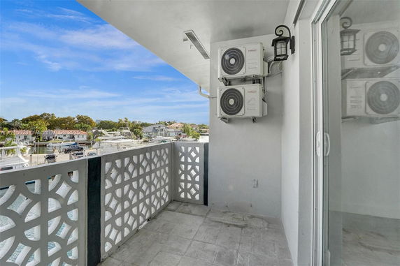 Balcony view with decorative railing and air conditioning units on the wall.