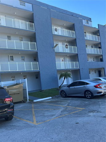 Front view of a multi-story apartment building with balconies.