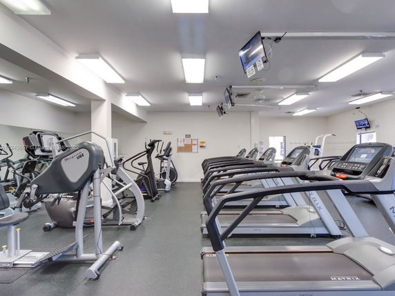 Indoor gym area with multiple treadmills and exercise equipment.