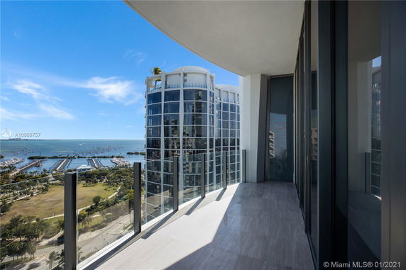 View from a high-rise balcony overlooking a marina and waterfront.