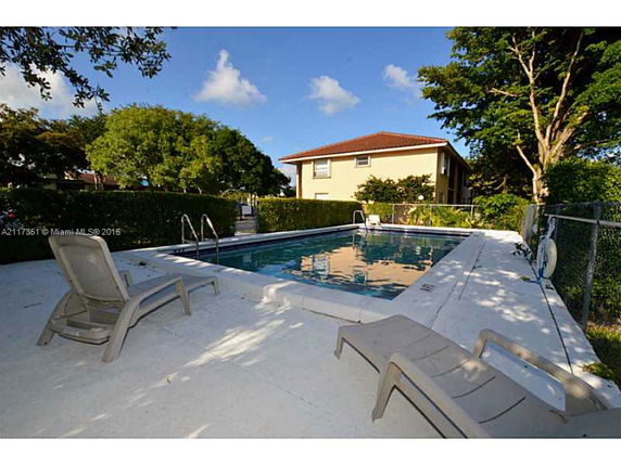 View of a two-story house with a swimming pool in the foreground.