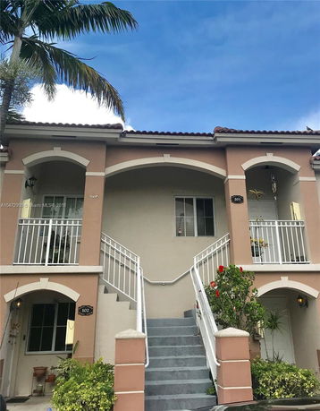 Front view of a two-story building with stairs leading to entrances.