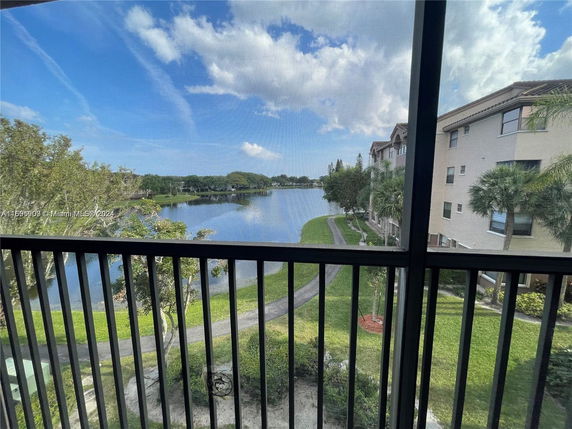 View from a building window showing a lake and surrounding greenery.