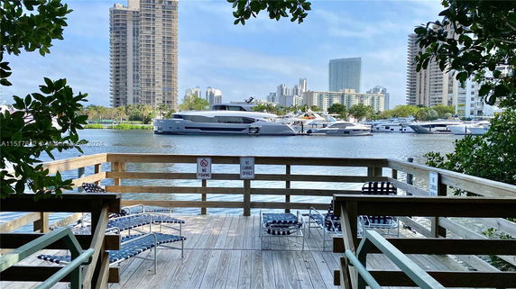 View from a deck showing a waterway with boats and distant high-rise buildings.
