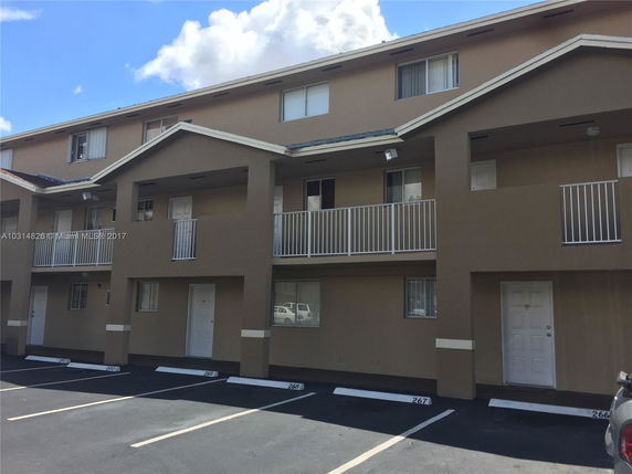 Front view of a multi-story apartment building with balconies.