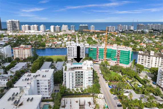 Aerial view of a coastal city skyline with various modern buildings and waterways.