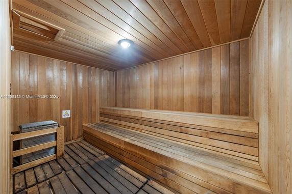 Interior of a wooden sauna room with benches and a heater.