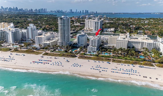 Aerial view of a coastal city with high-rise buildings, beaches, and ocean.