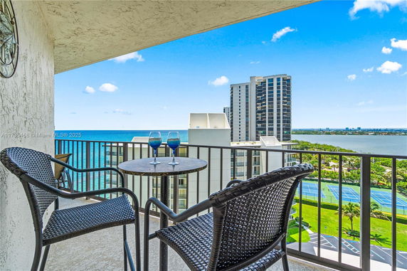 Balcony view with ocean and tennis courts in the background.
