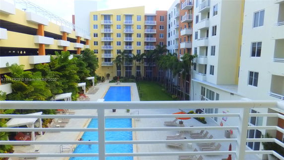 View of a swimming pool area surrounded by multi-story residential buildings.