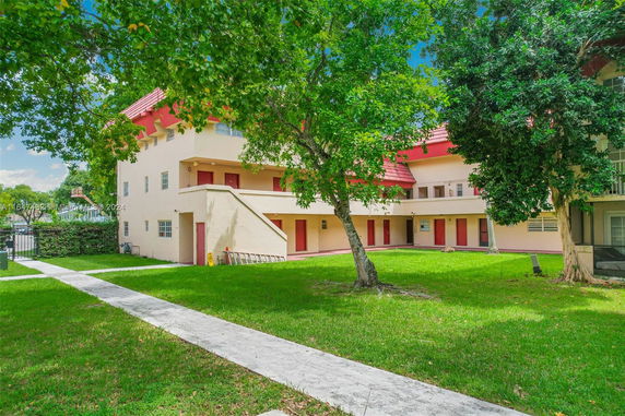 Front view of a multi-story building with red roofs and balconies.