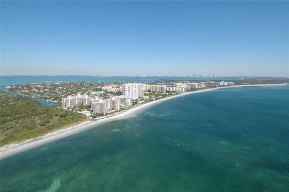 Aerial view of a coastal cityscape along a beach with buildings.