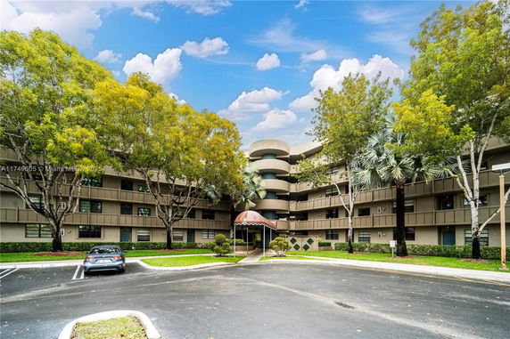 Front view of a multi-story residential building with a covered entrance.