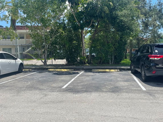 Outdoor parking area with designated visitor spot.
