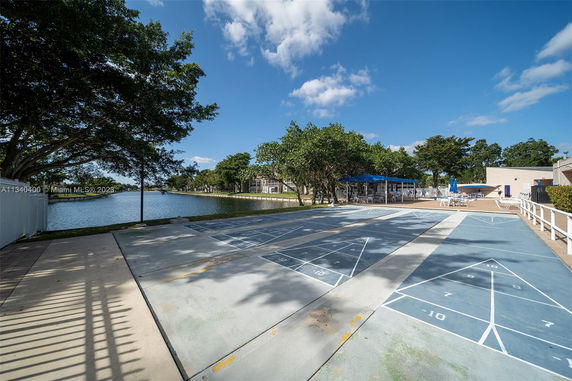 Outdoor play area with shuffleboard courts near a waterfront.