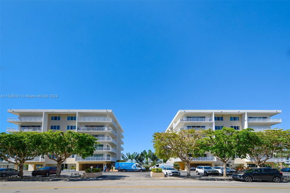 Front view of two adjacent four-story buildings with balconies.