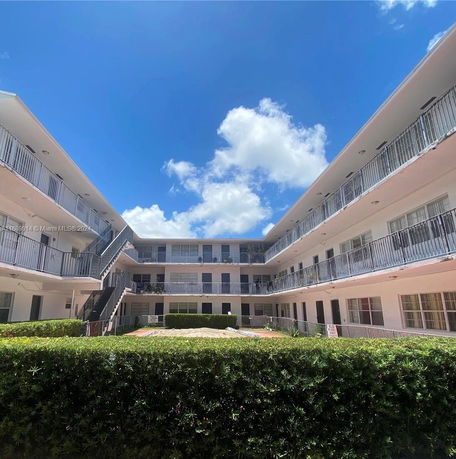 View of a three-story building with balconies and a central courtyard.