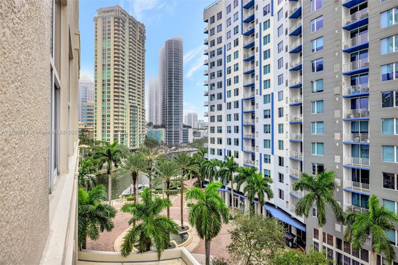 View of tall apartment buildings and palm trees in a city setting.