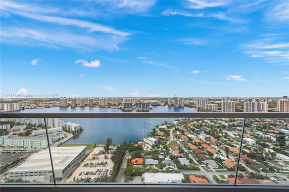 Panoramic view from a high vantage point overlooking a city with a body of water and numerous buildings.