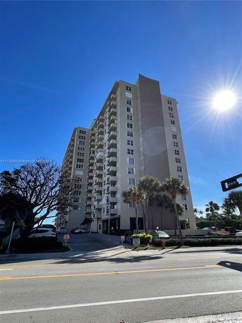Front view of a multi-story apartment building with balconies.