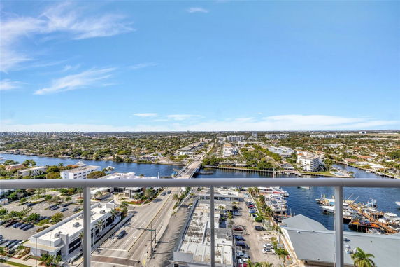 Panoramic view from a high vantage point overlooking a river, buildings, and roads with clear skies.