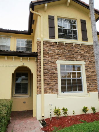 Front view of a two-story house with stone and stucco exterior.
