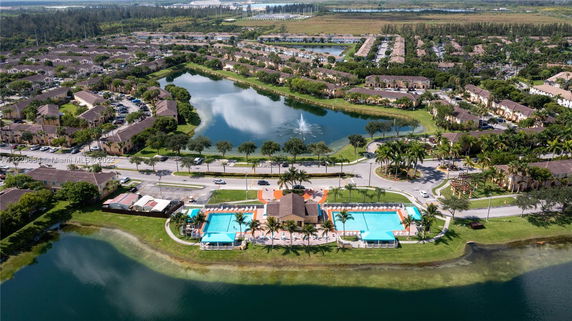 Aerial view of a residential area with houses and a central water body.