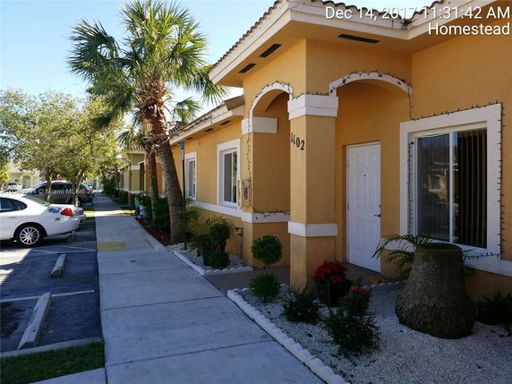 Front view of a single-story building with a yellow facade and white trim.
