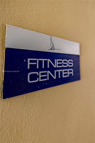 Close-up view of a fitness center sign on a wall.
