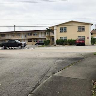 Front view of a two-story apartment building with parking space.