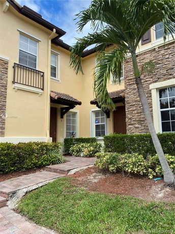 Front view of a two-story house with stone accents and yellow walls.