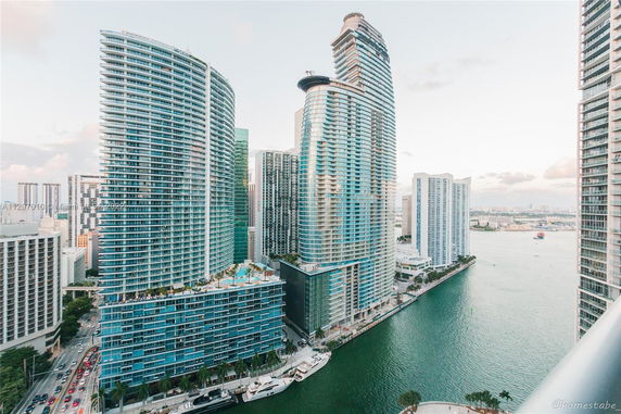 View of tall, modern high-rise buildings near a waterfront.