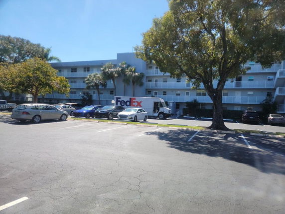 Outdoor parking area in front of a multi-story building.