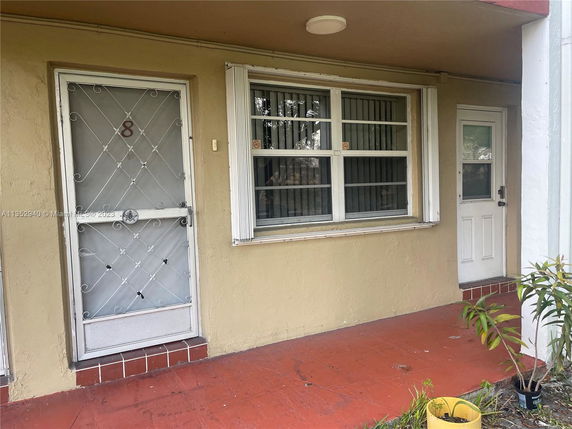 Front view of a building with a security screen door and a window.